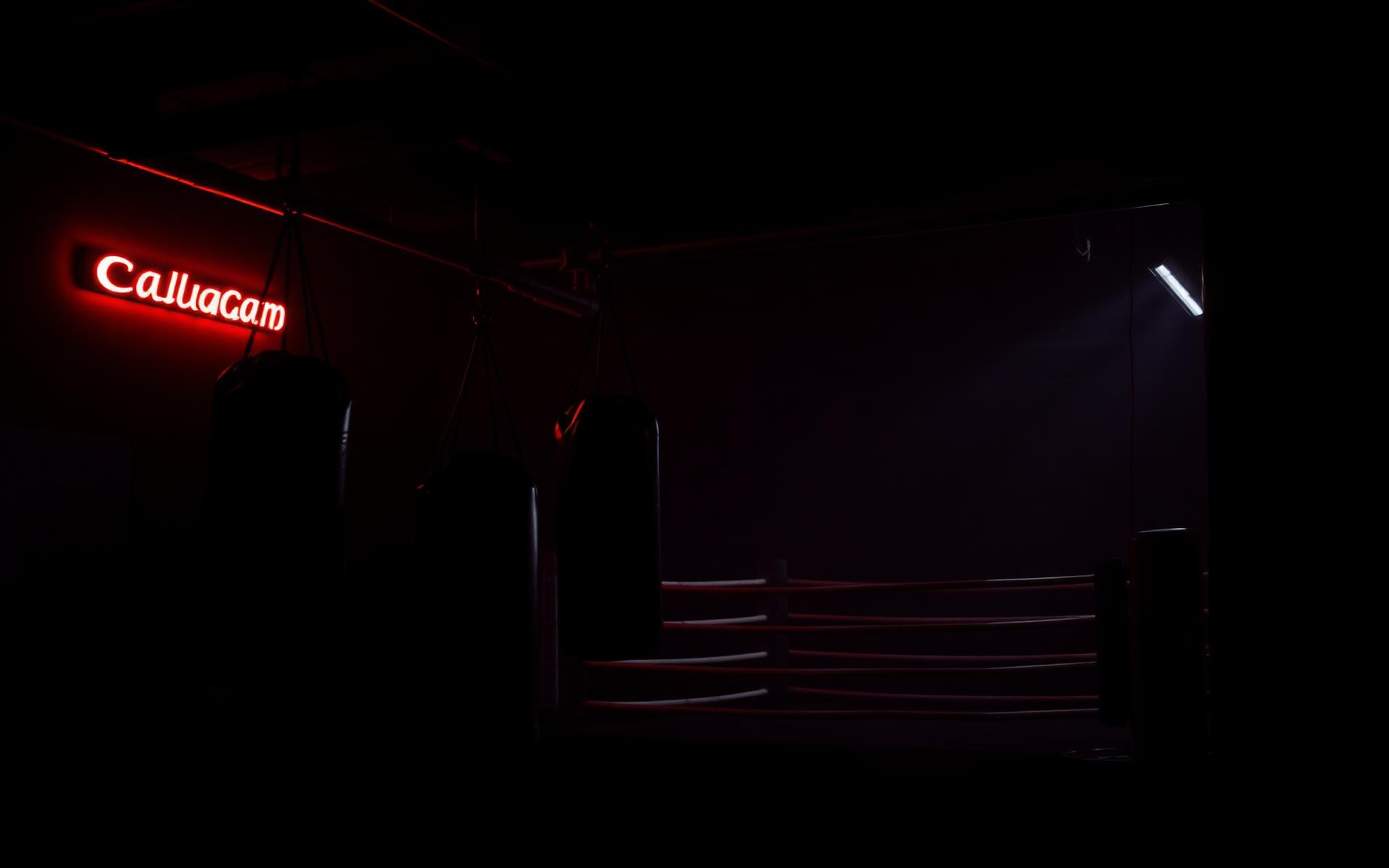Dark boxing gym with red neon lighting